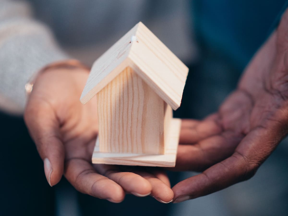 Petite maison miniature posée sur des pièces de monnaie illustrant le cash flow immobilier