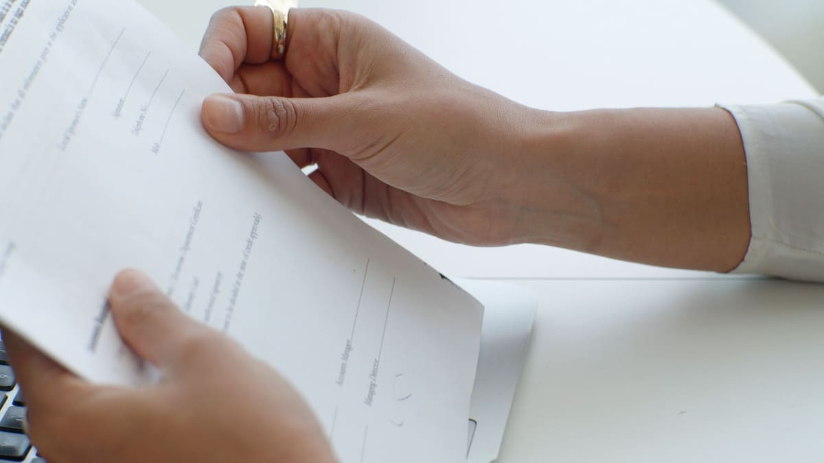 Locataire relisant les clauses d'un contrat de location avant signature